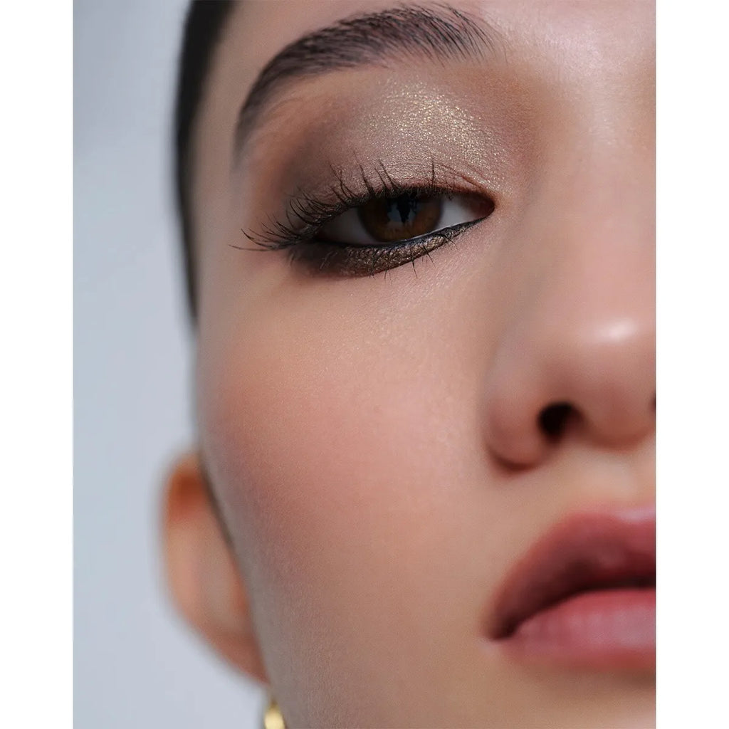 Close-up of a model wearing Addiction The Creamy Stick Eyeshadow in olive green, showcasing a dramatic and sophisticated eye makeup effect.