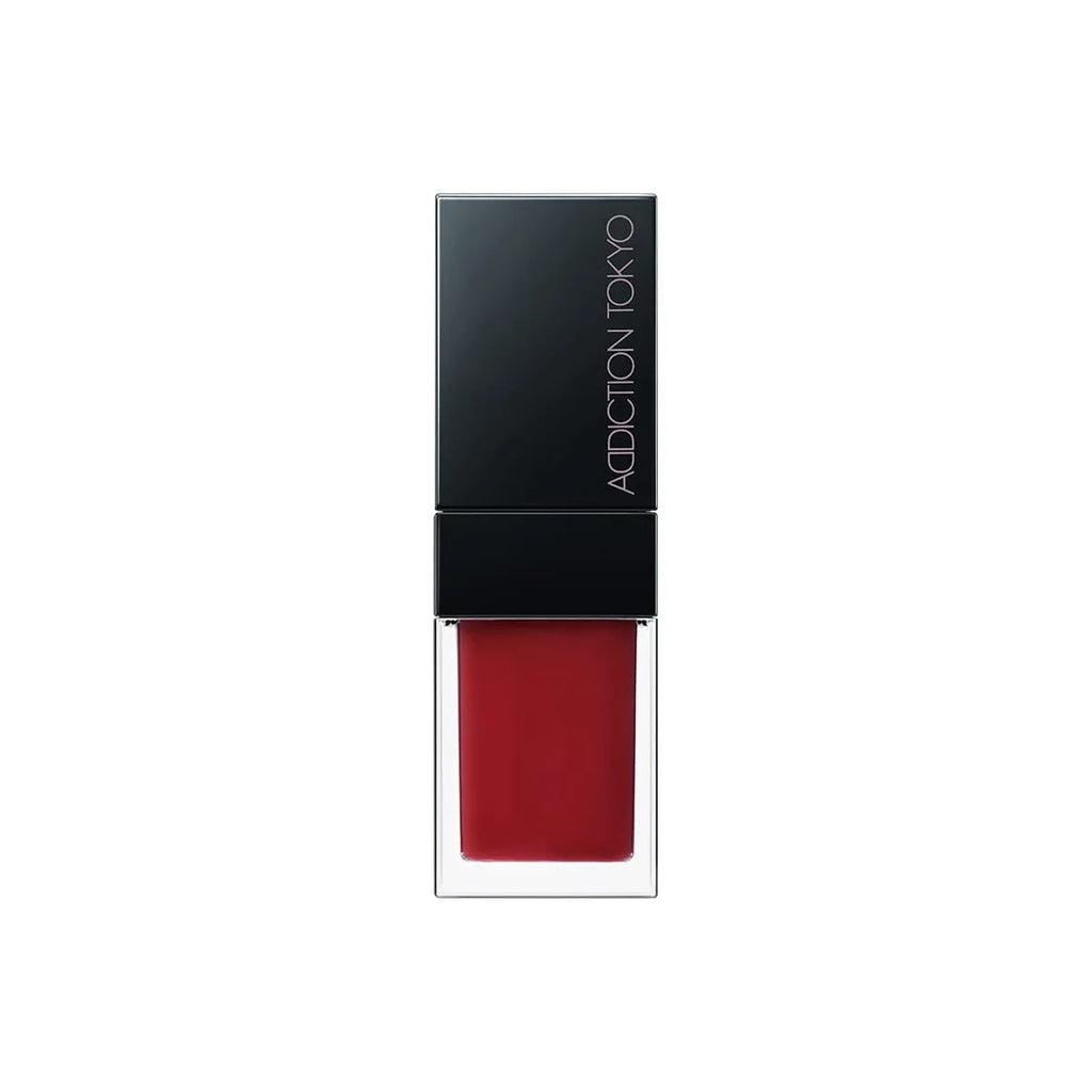 Addiction Tokyo Lip Oil Plumper 6.5ml in deep red shade with a black cap, delivering a bold and hydrating lip look.