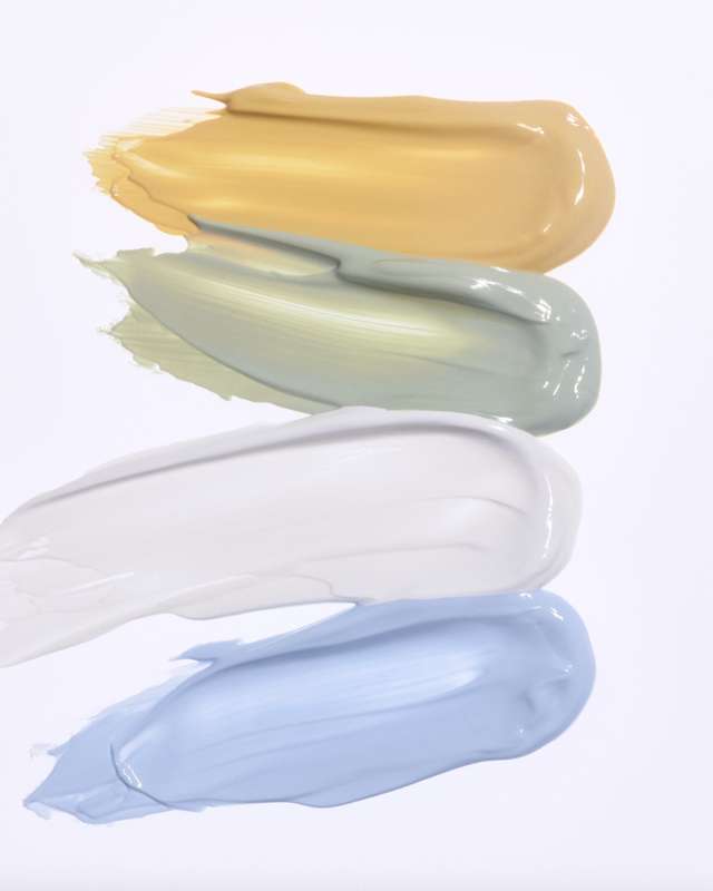 Swatches of Tokyo Color Corrector in yellow, green, white, and blue shades. Showcases creamy texture and blendable formula for skin correction.