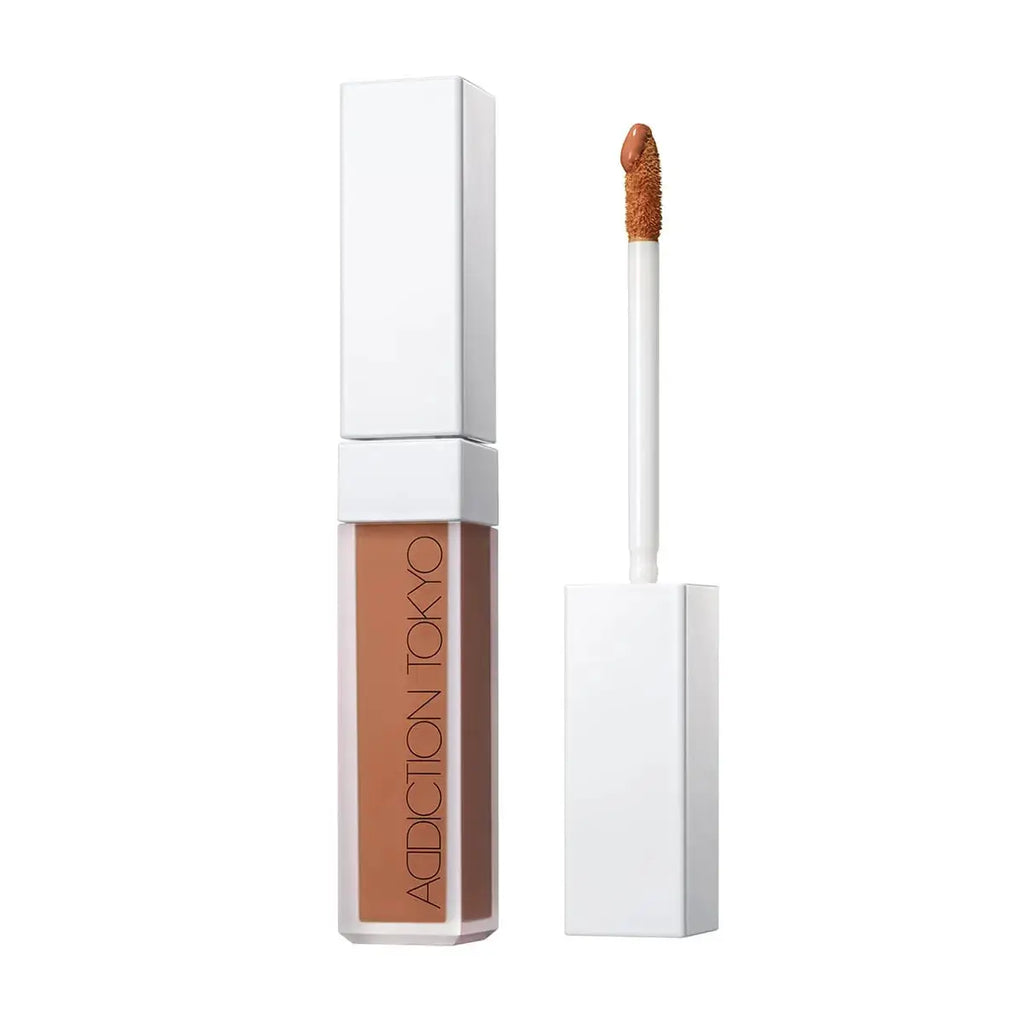 Tokyo Color Corrector in Deep shade with a sleek white tube and applicator. Provides seamless coverage and enhances skin tone balance.