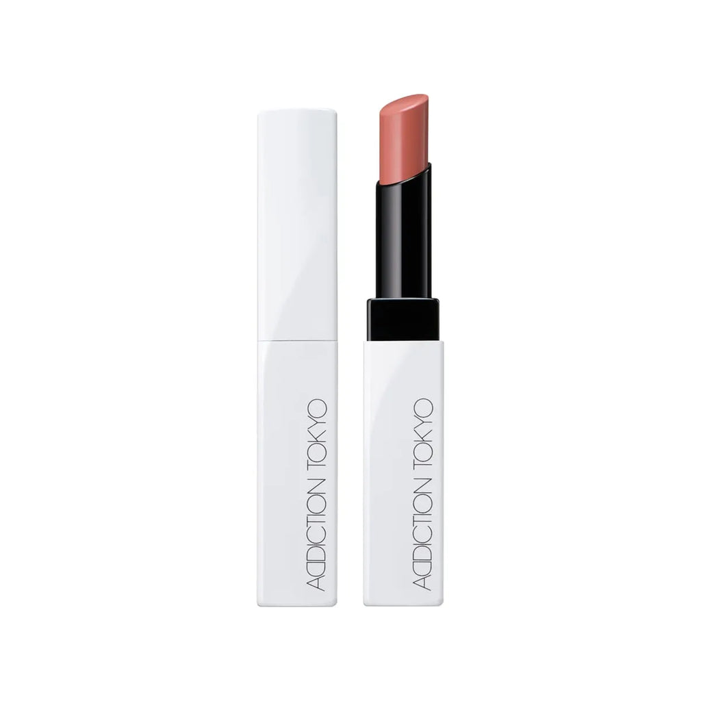 Addiction Tokyo Lip Balm Glow Tint in a soft pink shade, housed in a minimalist white and black tube for a natural glossy look.