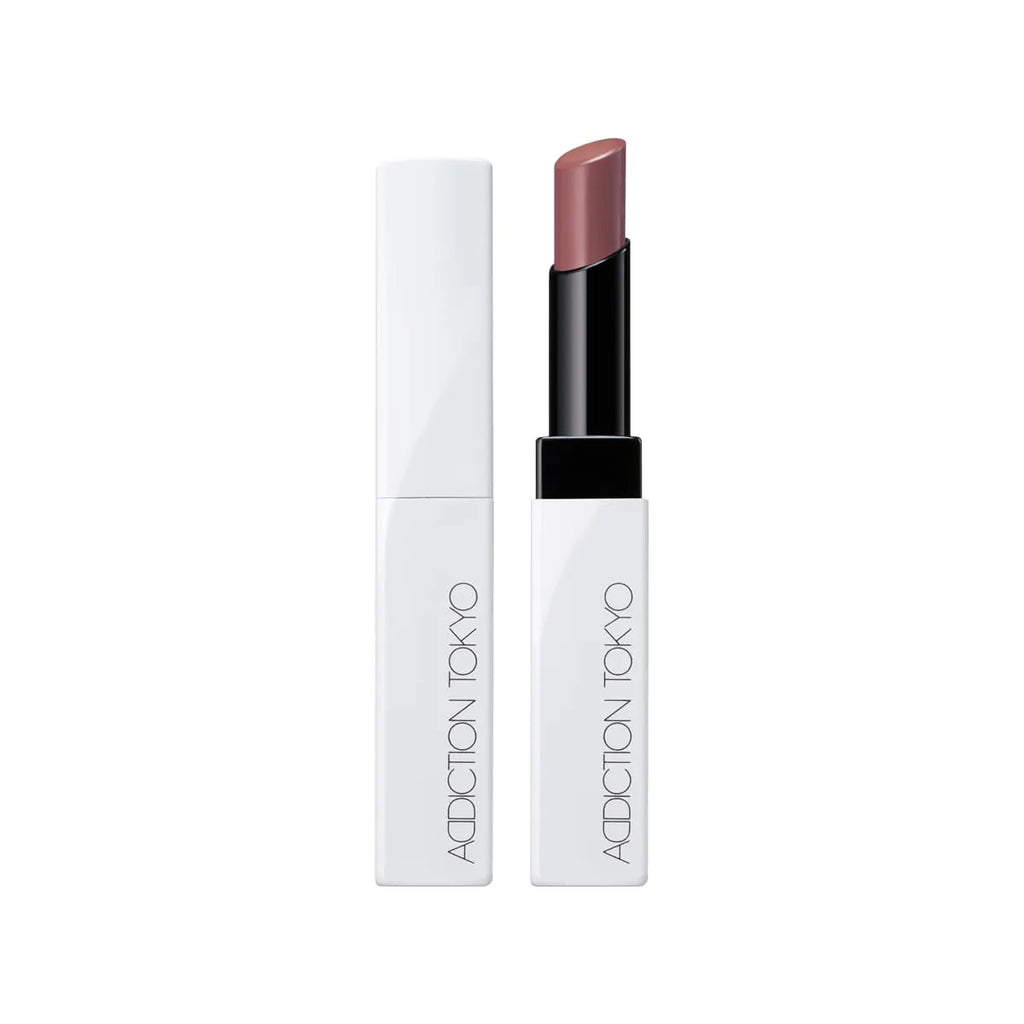 Addiction Tokyo Lip Balm Glow Tint in a mauve shade, presented in a sleek white and black tube for a sophisticated glossy tint.