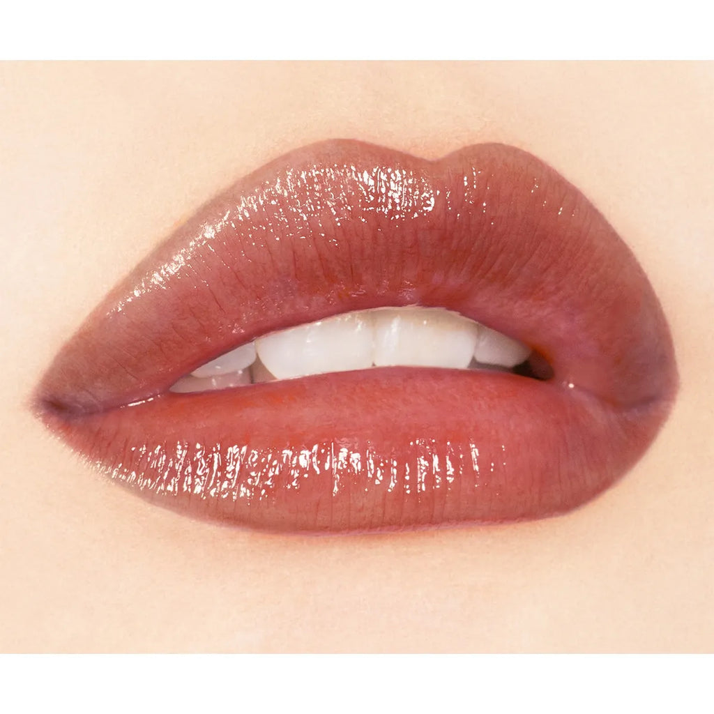 Close-up of lips wearing Addiction Tokyo Lip Balm Glow Tint in a brownish nude shade, showcasing a smooth, glossy effect.