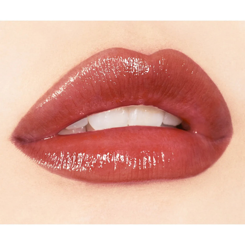 Close-up of lips wearing Addiction Tokyo Lip Balm Glow Tint in a burgundy shade, showcasing a deep, glossy effect.