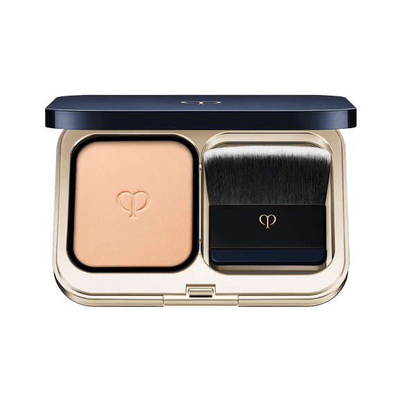 Clé de Peau Beauté Teint Pouder Éclat Ⅱ foundation in a sleek navy and gold compact with a premium brush for seamless blending.