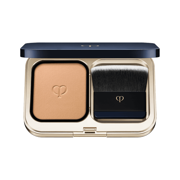 Clé de Peau Beauté Teint Pouder Éclat Ⅱ foundation in a sophisticated navy and gold compact, featuring a premium brush for smooth application.