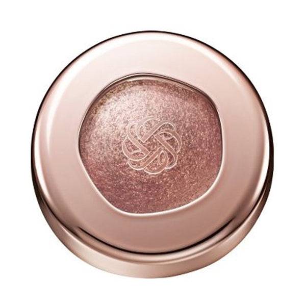 Cosme Decorté Eye Glow Gem Skin Shadow in a coppery pink shade with a metallic sheen, encased in a rose gold compact.