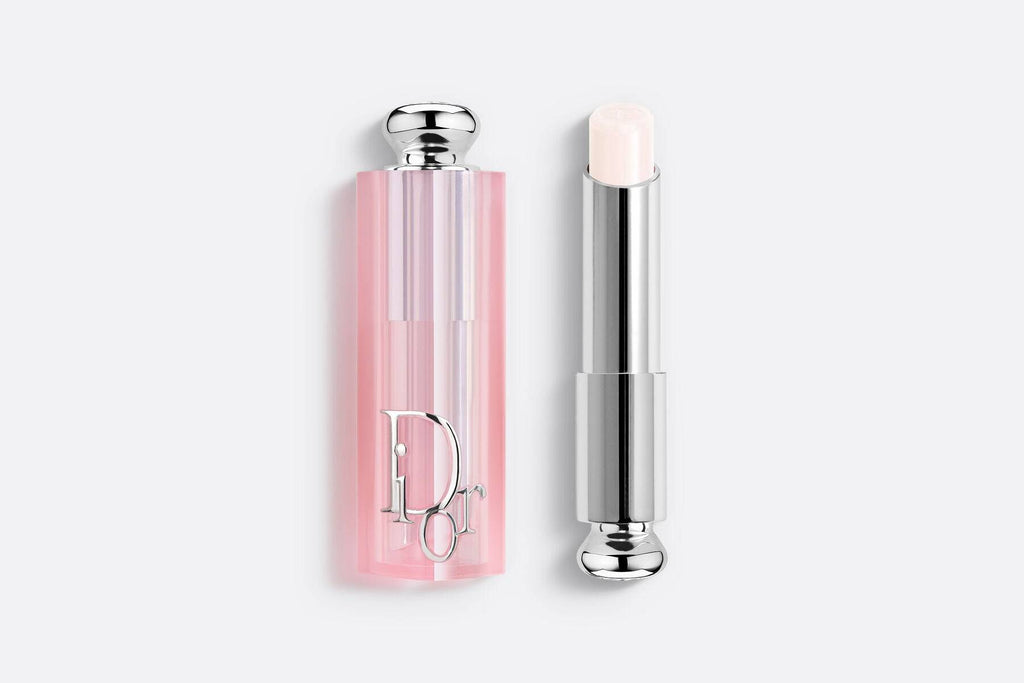 Dior Addict Lip Glow lipstick in a sheer, hydrating formula with a light nude shade. Encased in a pink translucent tube with silver accents.