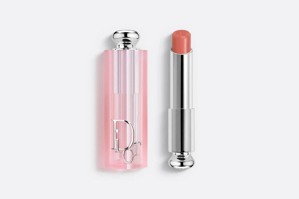 Dior Addict Lip Glow lipstick in a warm beige tone, offering a subtle, moisturizing tint. Comes in a pink translucent case with silver details.