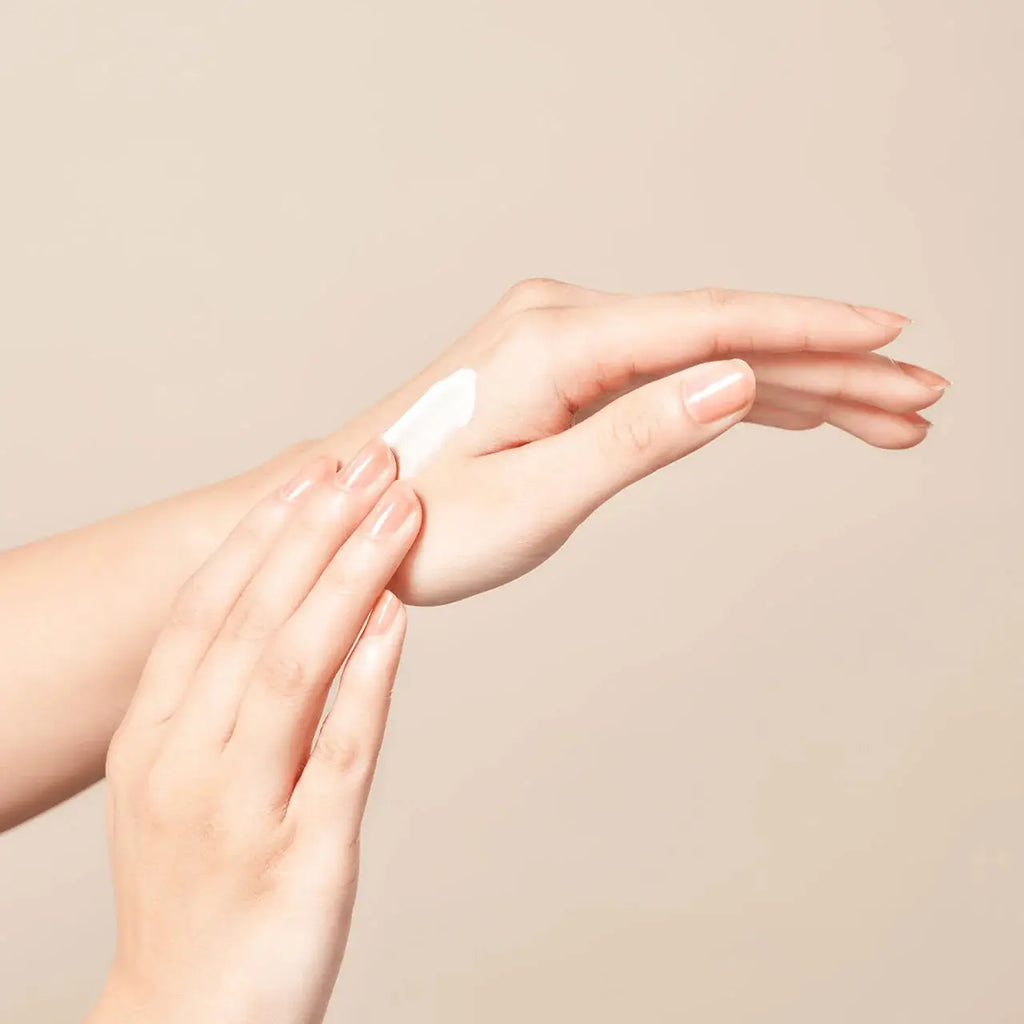 Elégance Aqua Clear Smooth Shield UV sunscreen applied to hand. Lightweight, smooth formula absorbs easily, offering SPF50+ PA++++ protection.