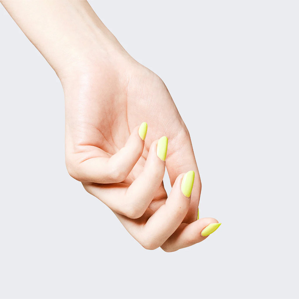 Hand with nails painted in lime green Elégance Lacquer, highlighting a smooth matte finish for a fresh, modern look.