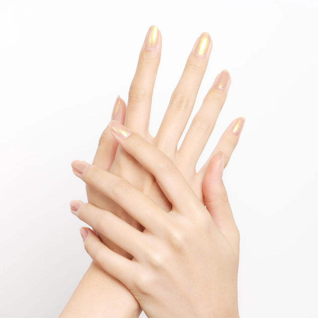 Hands with nails painted in iridescent peach Elégance Lacquer, showcasing a soft shimmer finish for an elegant touch.