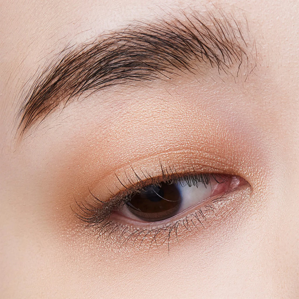 Close-up of an eyelid wearing Elégance Razzle Eye Color in a soft gold shade, showcasing a luminous and natural eye makeup look.