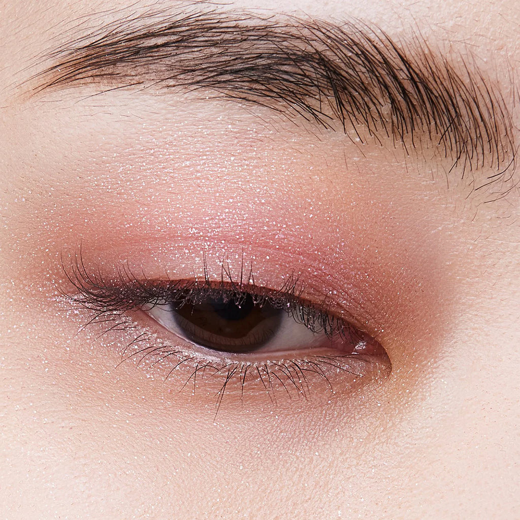 Close-up of an eyelid adorned with Elégance Razzle Eye Color in pink, delivering a soft, glittery finish for a feminine look.