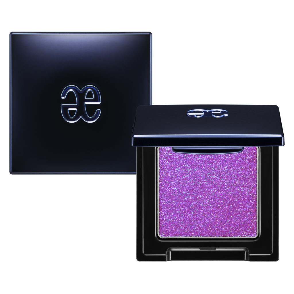 Elégance Razzle Eye Color in vibrant purple shade, encased in a sleek black compact. Perfect for striking and colorful eye makeup.