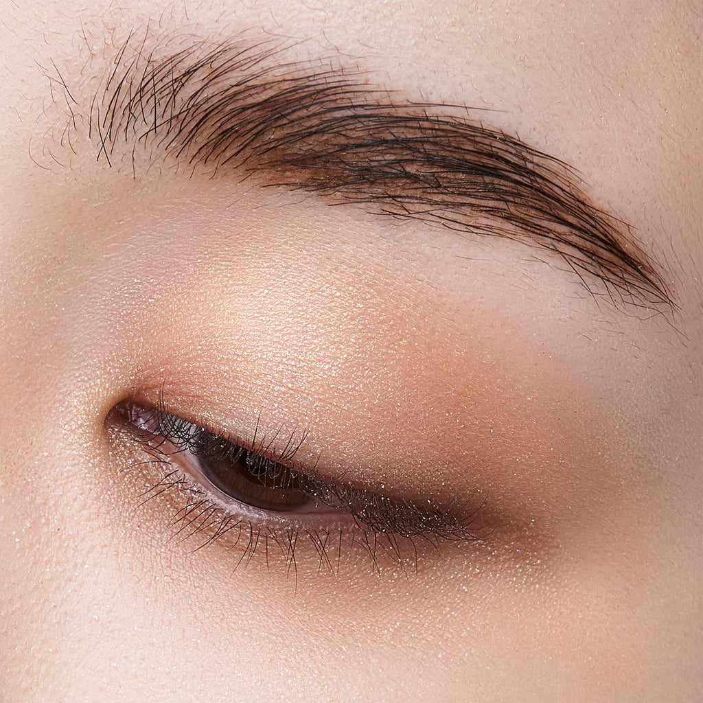 Close-up of an eyelid with Elégance Razzle Eye Color in metallic gold, creating a subtle and glowing eye makeup effect.