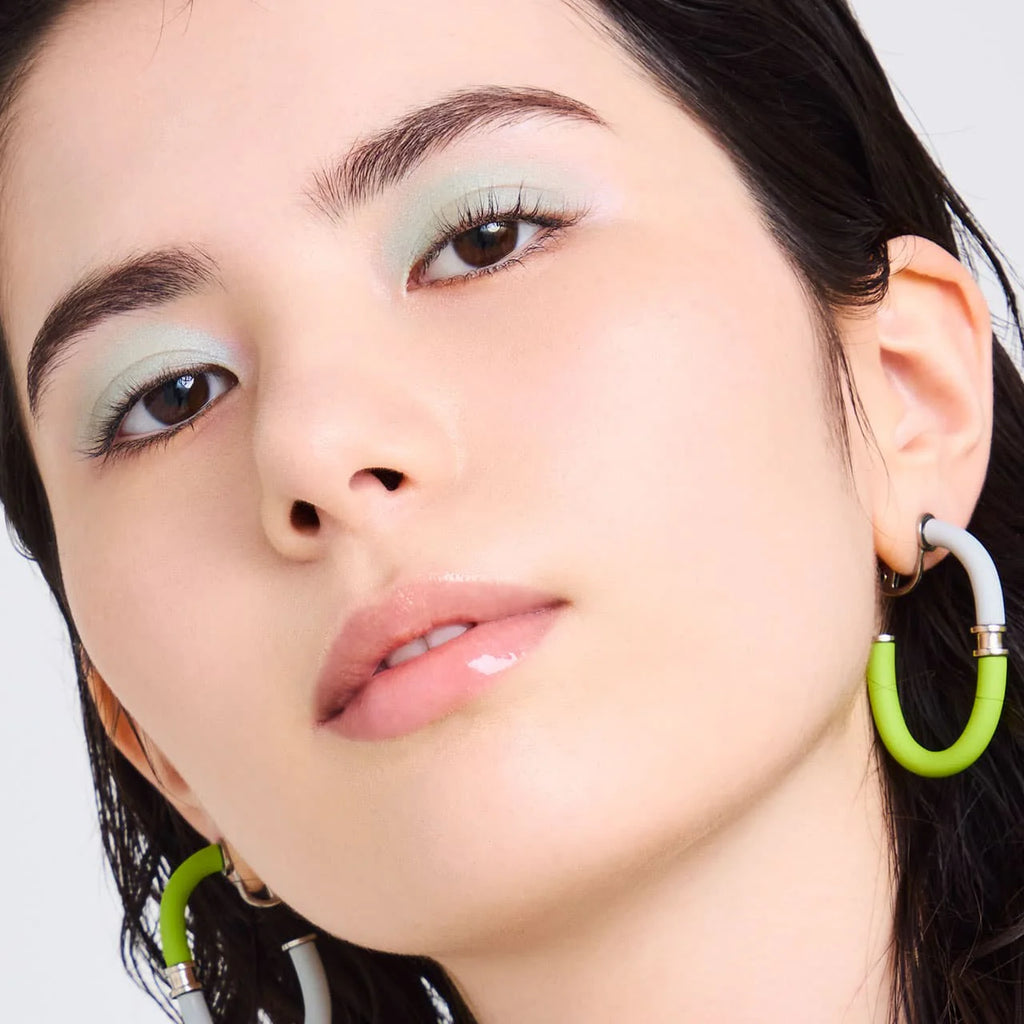 Close-up of a model wearing Elégance Razzle Eye Color in green, showcasing a fresh and luminous eye makeup look.