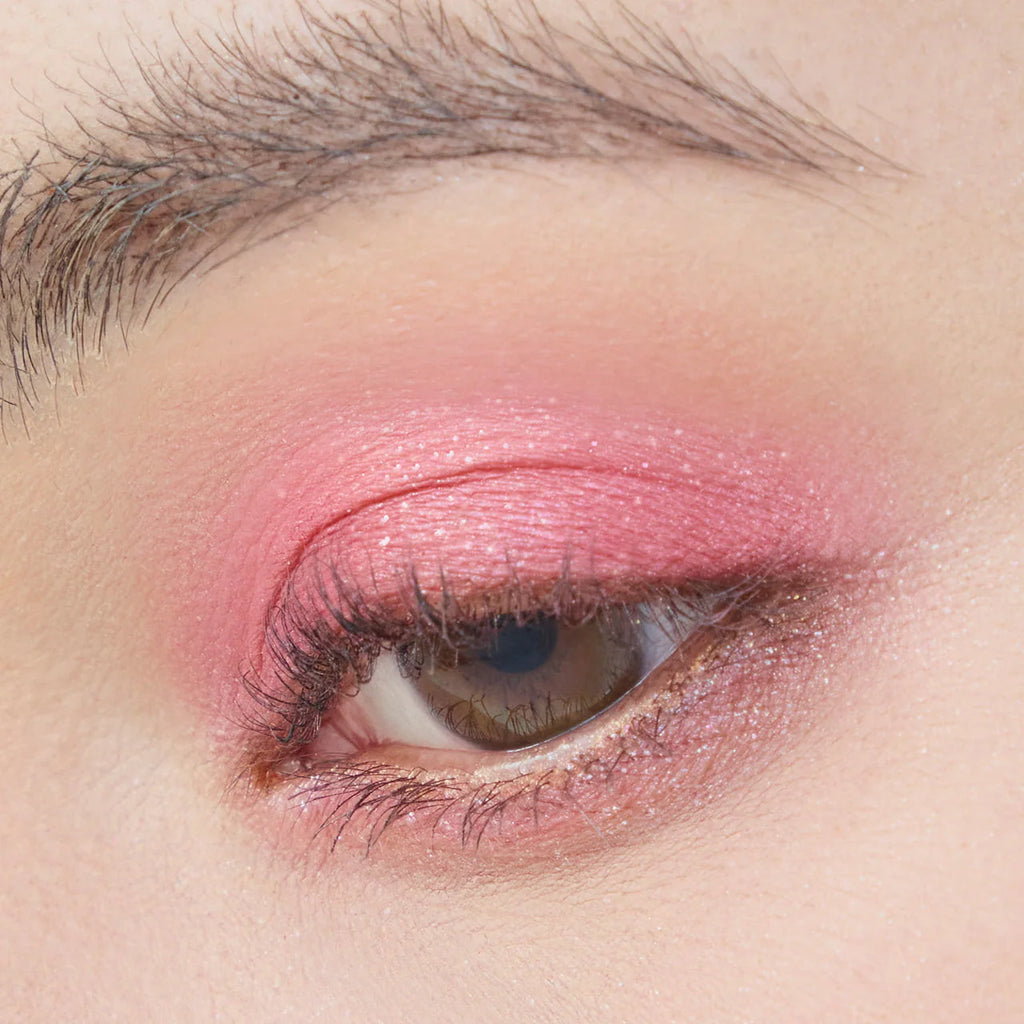 Close-up of an eyelid adorned with Elégance Razzle Eye Color in coral pink, showcasing a fresh and radiant eye makeup look.