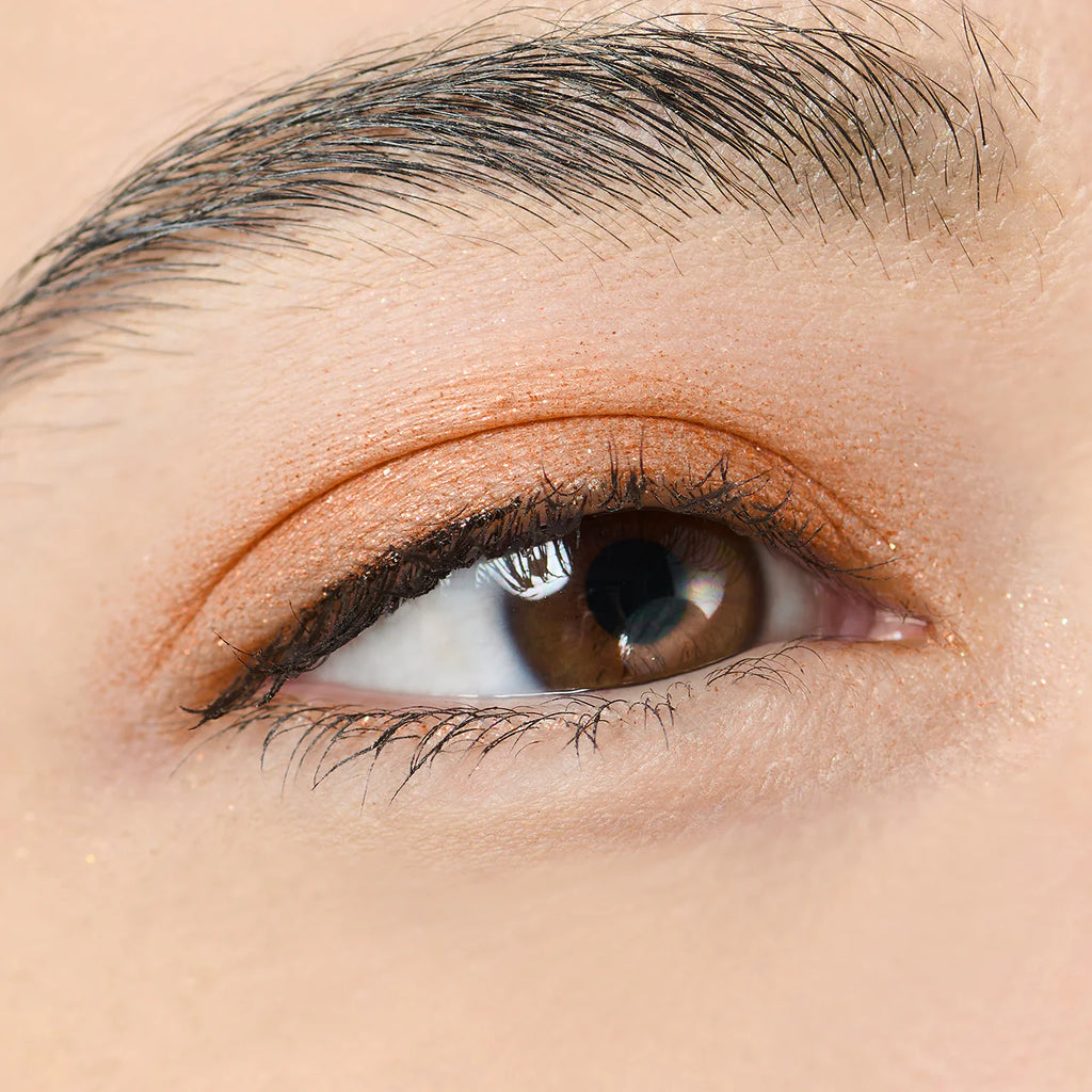 Close-up of an eye wearing Elégance Razzle Star Eye Color in orange, showcasing its vibrant and smooth application on the eyelid.