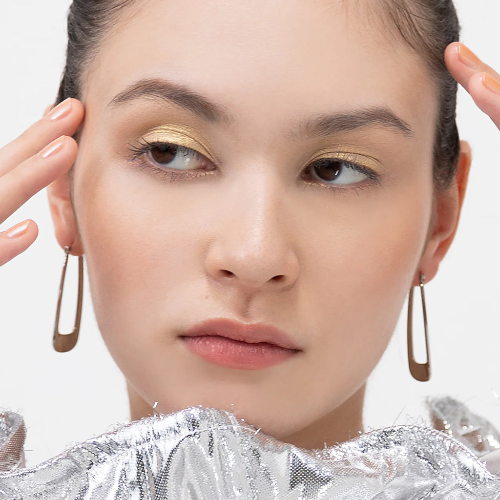 Model showcasing Elégance Razzle Star Eye Color in silver, emphasizing its luminous shine and smooth eye makeup application.