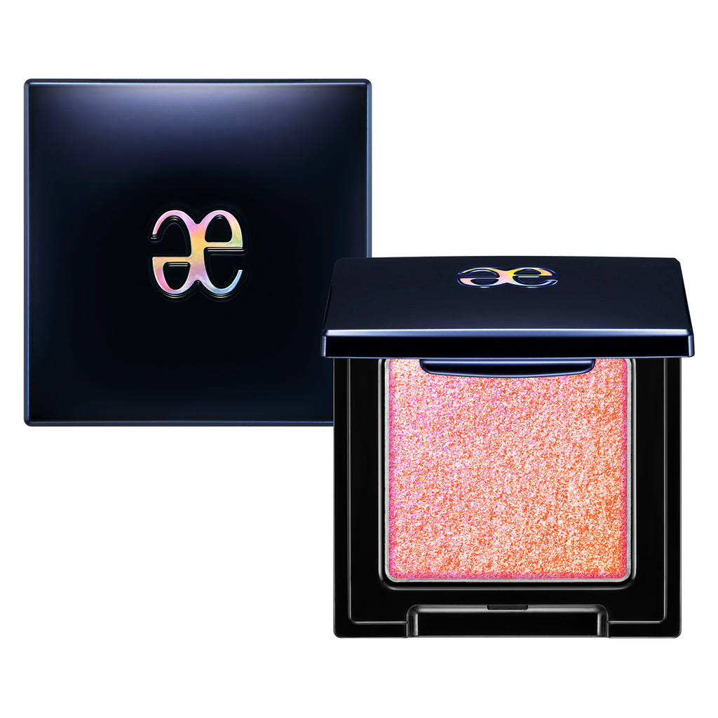 Elégance Razzle Star Eye Color in a pinkish-orange duochrome shade with a glittery finish, housed in a sleek black compact with a glossy logo.