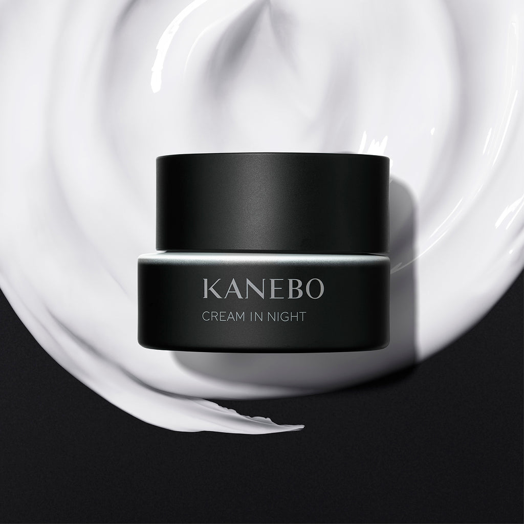 Kanebo Cream in Night 40g black jar displayed on a smooth cream texture background, emphasizing hydration and luxury.