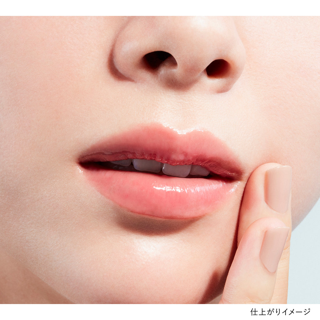 Close-up of lips wearing Kanebo Rouge Scrub Melting lipstick in a vibrant red shade, highlighting a glossy and polished finish.