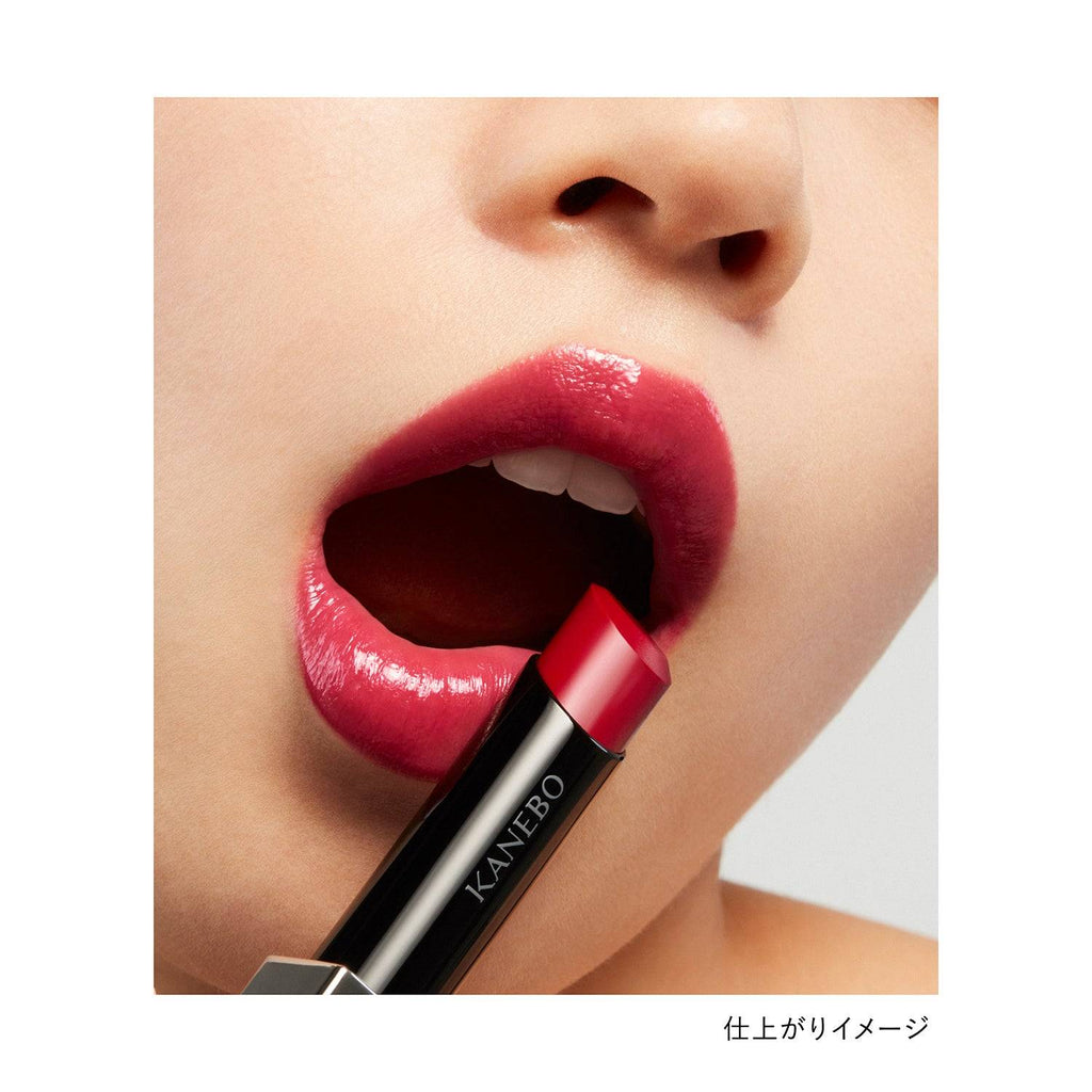 Model applying Kanebo Rouge Star Vibrant lipstick in a deep red shade, highlighting a glossy and bold finish.