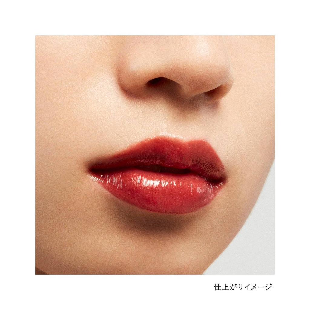 Lips wearing Kanebo Rouge Star Vibrant lipstick in a brownish-red shade, showcasing a glossy and natural finish.