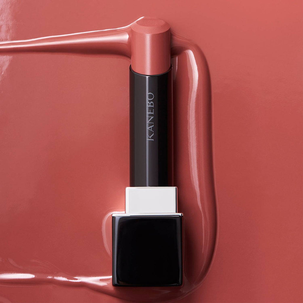 Kanebo Rouge Star Vibrant lipstick in a peachy nude tone, highlighted against a matching background with a smooth, radiant finish.