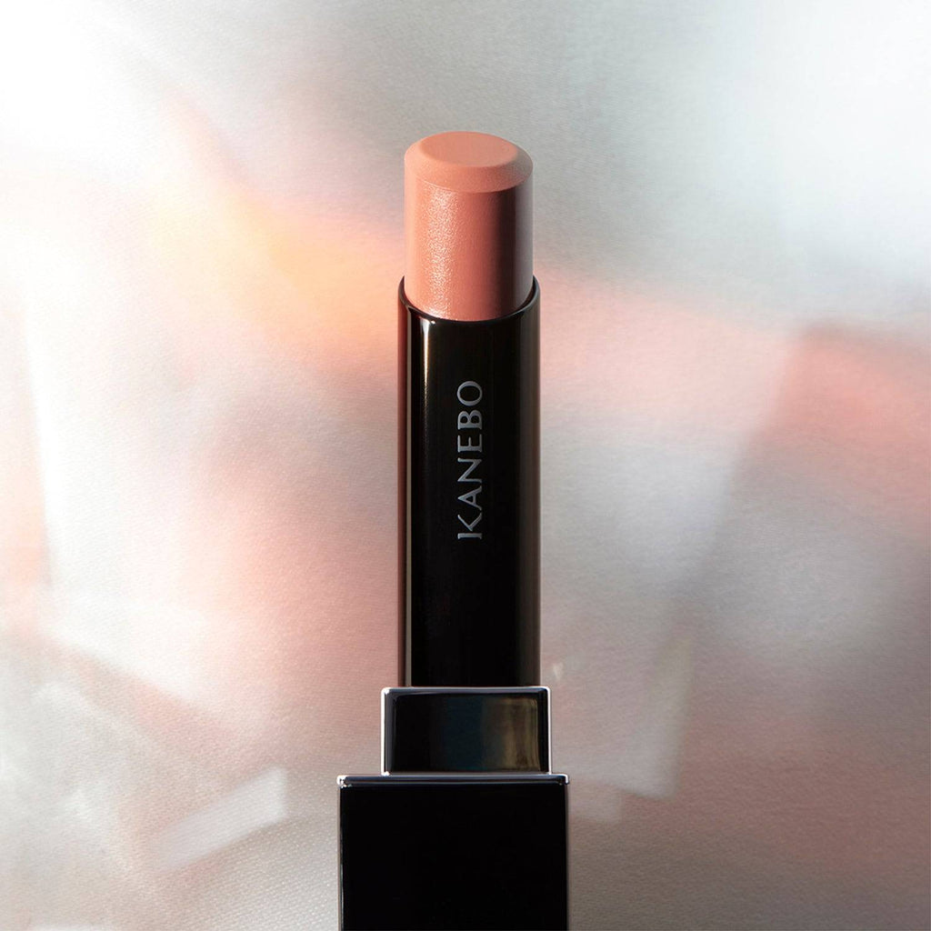 Kanebo Rouge Star Vibrant lipstick in a soft peach tone, set against a glowing background with a smooth, radiant finish.