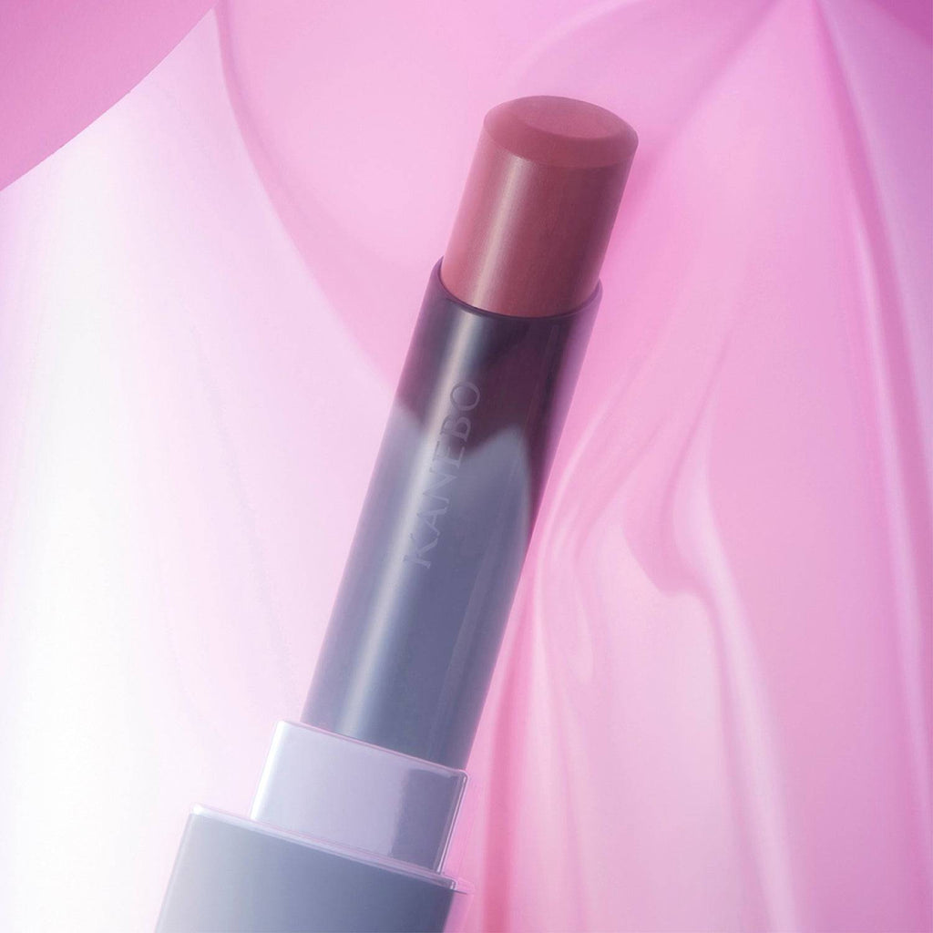 Kanebo Rouge Star Vibrant lipstick in a mauve tone, highlighted against a soft pink background with a smooth, radiant finish.