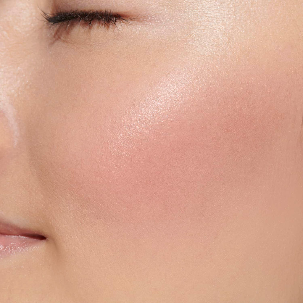 Close-up of a model's cheek showcasing the rosy pink shade of Lunasol Coloring Sheer Cheeks (Glow) for a natural glow.