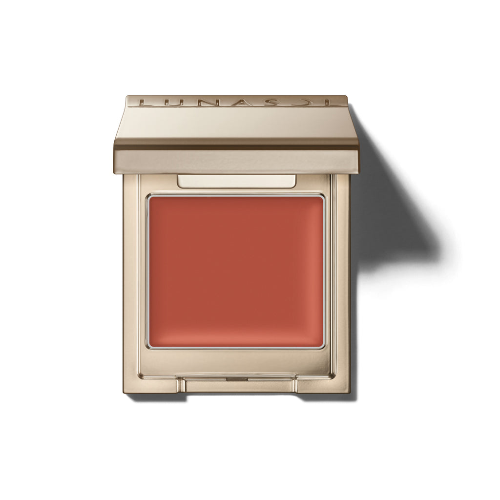 Lunasol Mono Eye Coloration cream eye shadow in a warm coral shade, housed in a sleek gold compact for smooth application.