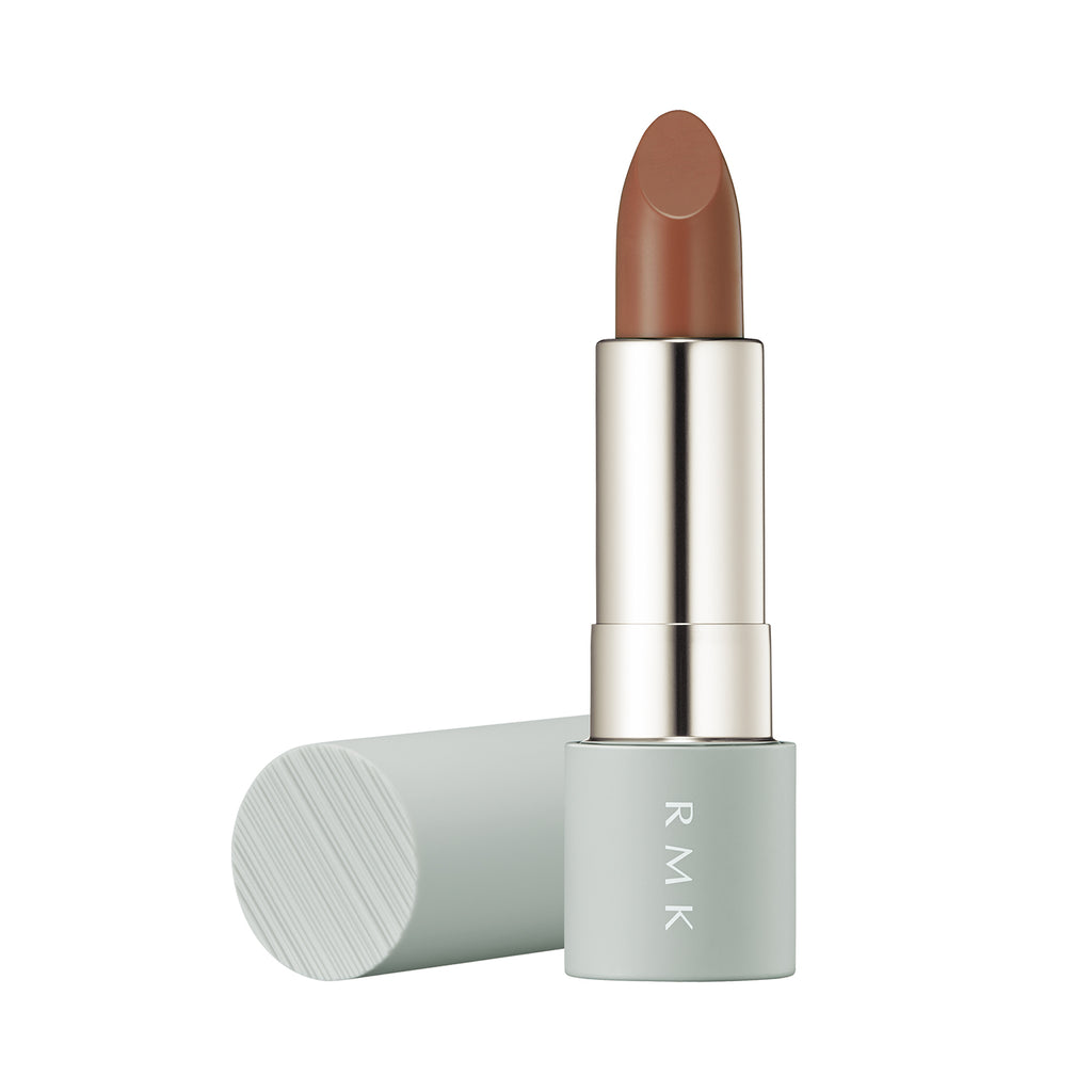 RMK The Matte Lip Color 4g in shade 11 Urban Bourbon, a peachy nude beige lipstick with a matte finish, in a sleek mint green case.