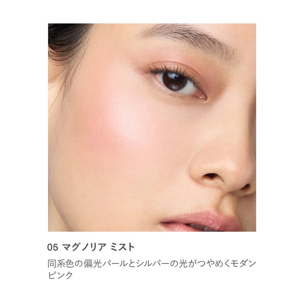 Close-up of RMK Radiant Color Stick 6.4g in shade 05 Magnolia Mist applied on skin, showing a modern pink shimmer.