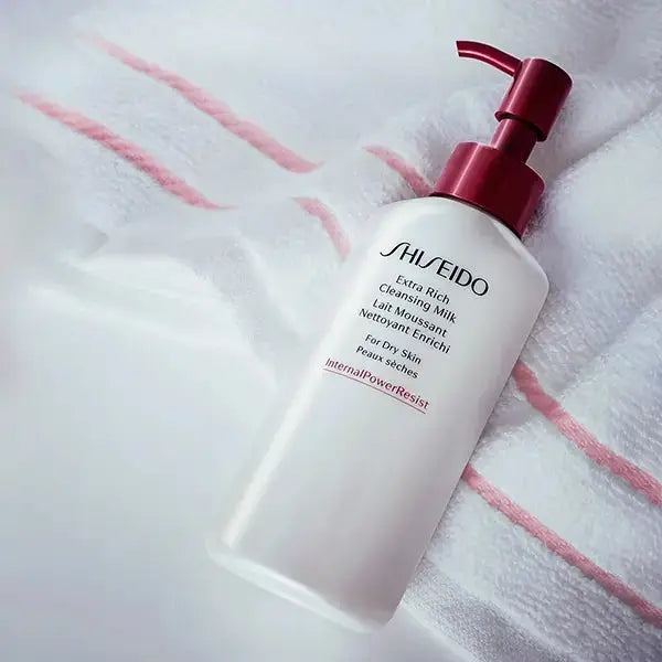 Shiseido Cleansing Milk 125ml bottle on a soft towel backdrop. Designed for dry skin, this hydrating cleanser ensures smooth and nourished skin.