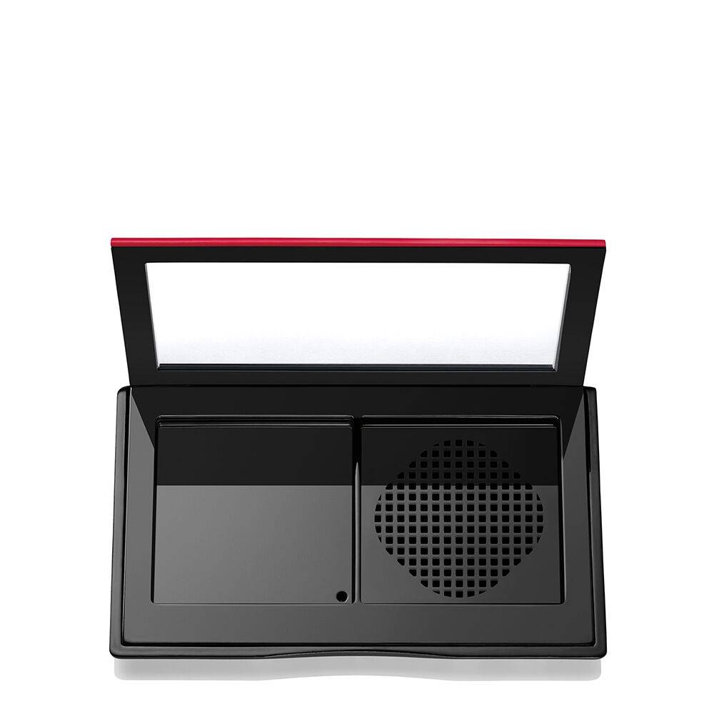Empty Shiseido Synchro Skin compact case with a built-in mirror and compartments for powder and sponge storage.