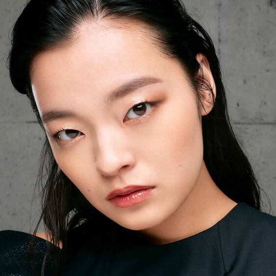 Model wearing Shu Uemura Eye Sculpt eye shadow, showcasing a natural and defined eye makeup look with neutral tones.