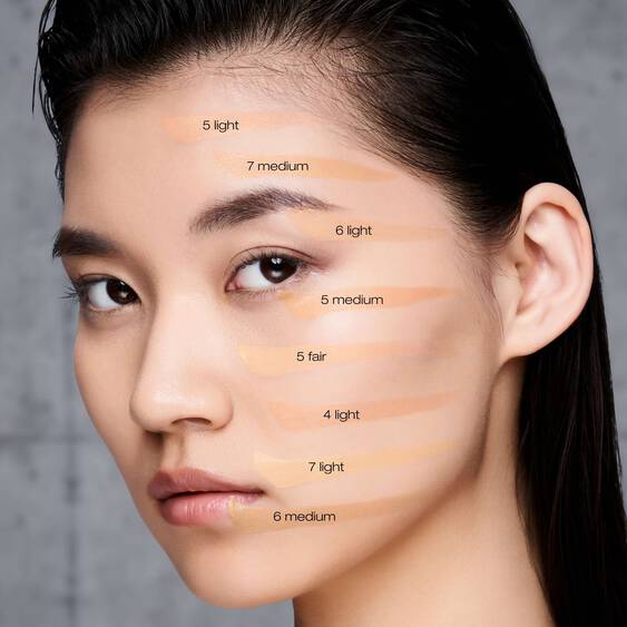 Model showcasing Shu Uemura Unlimited Care Face Calligraphy foundation shades on her face. Available in multiple tones for a perfect match.