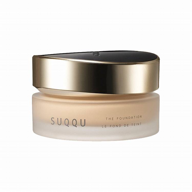 Suqqu The Foundation 30g in a frosted jar with a sleek gold and black lid, ideal for achieving a flawless glossy glow.