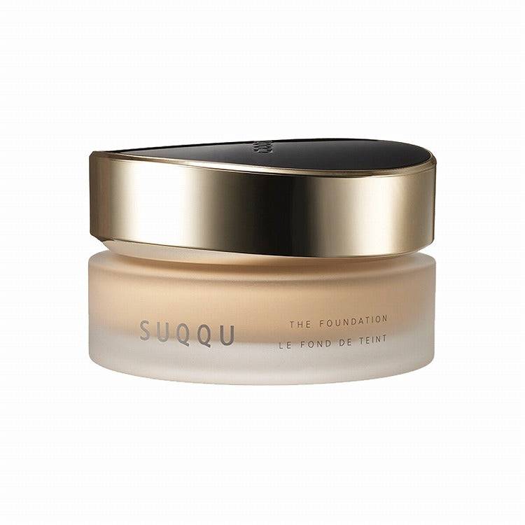 Suqqu The Foundation 30g in a frosted jar with a gold and black lid, offering SPF protection and a rich glossy glow.