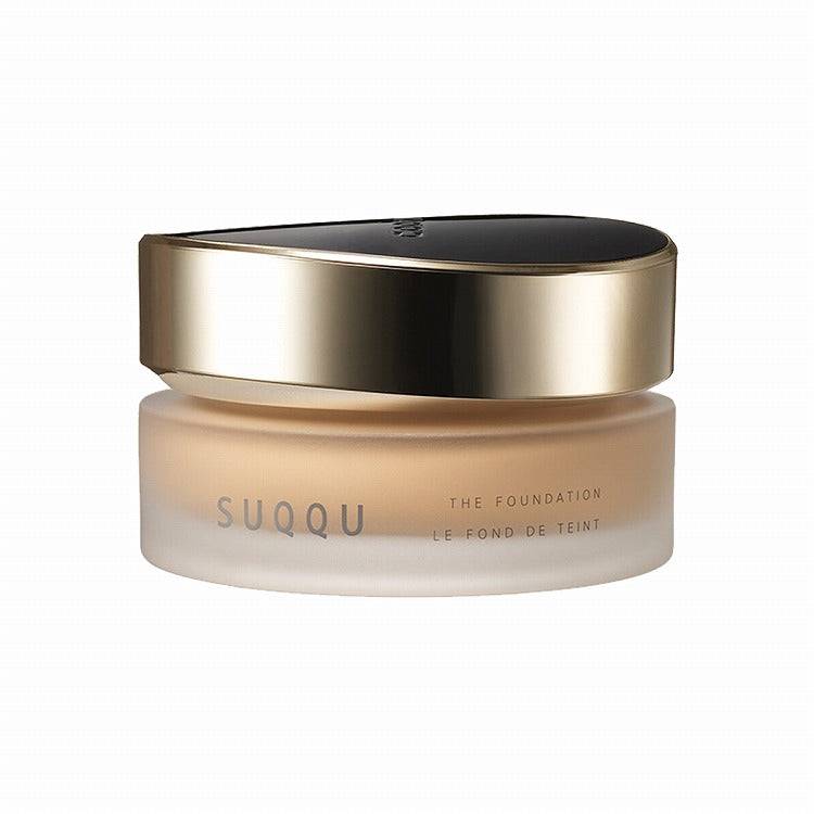 Suqqu The Foundation 30g in a frosted jar with a gold and black lid, designed for a flawless and luminous makeup look.