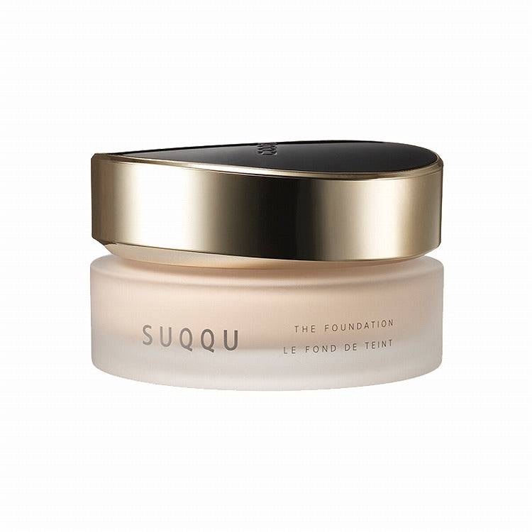 Suqqu The Foundation 30g in a frosted jar with a sleek gold and black lid, ideal for achieving a flawless glossy glow.