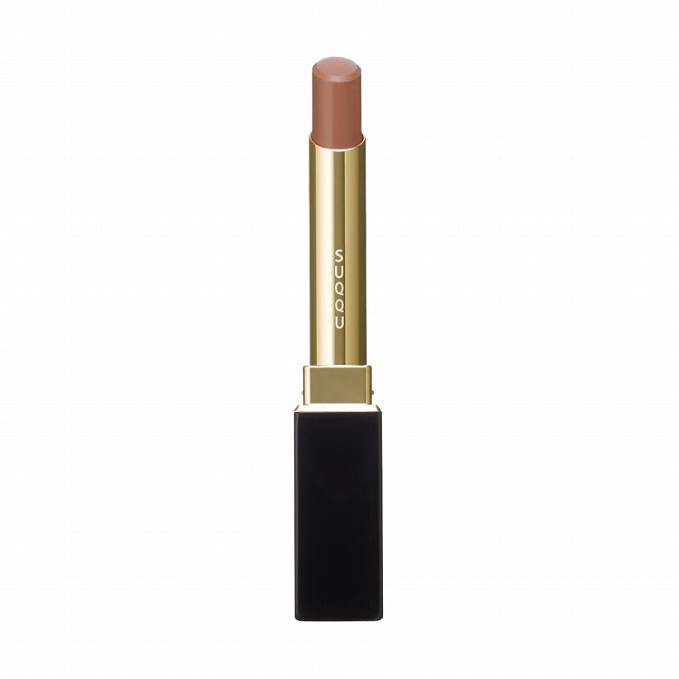 Suqqu Velvet Fit Lipstick in a nude beige shade with a sleek black and gold tube, offering a creamy texture for smooth application.