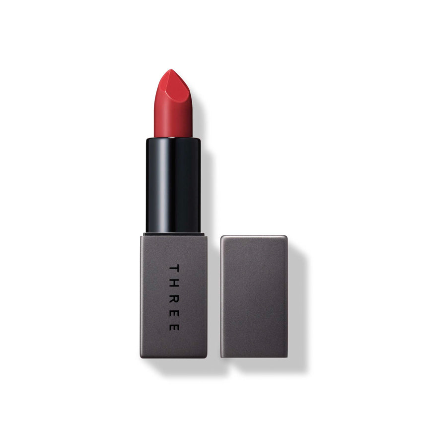 Three Dream On Alluring Lip Stick in shade 06 Beautiful Kingdom, a deep red tone with elegant gray packaging. Ideal for dramatic lip looks.