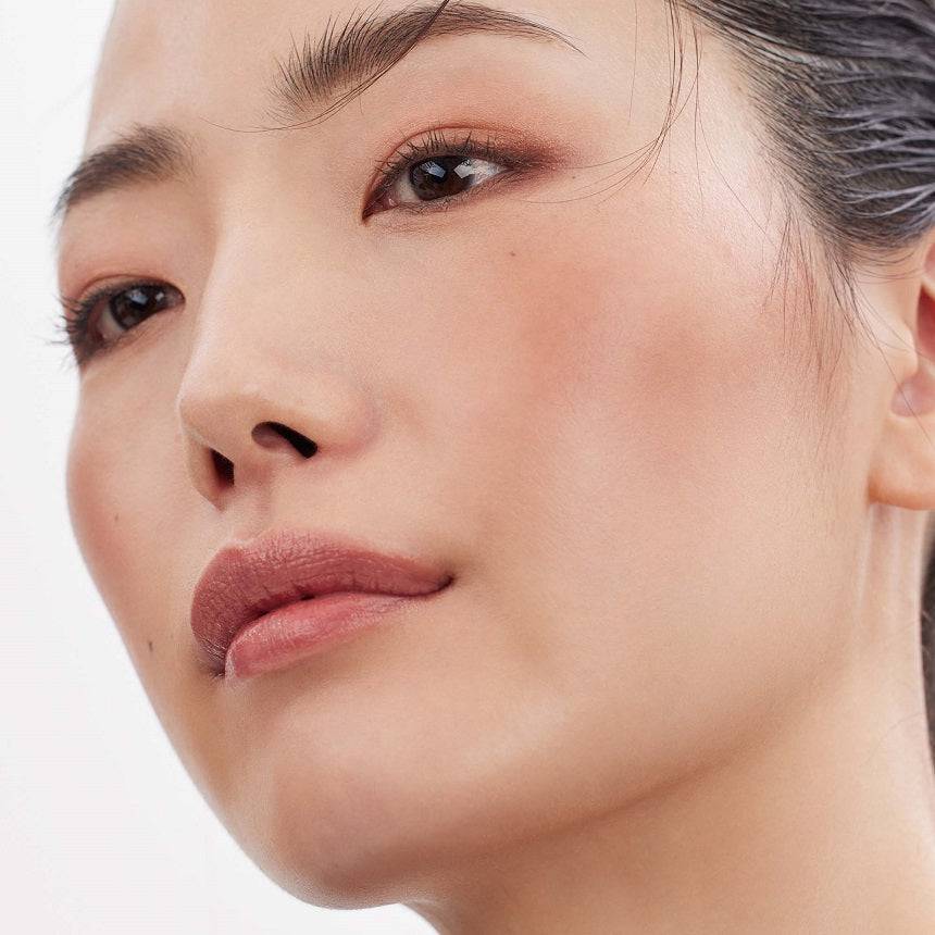 Close-up of a model's face with a luminous glow, achieved using the Three Shimmering Glow Duo for cheek and highlight enhancement.