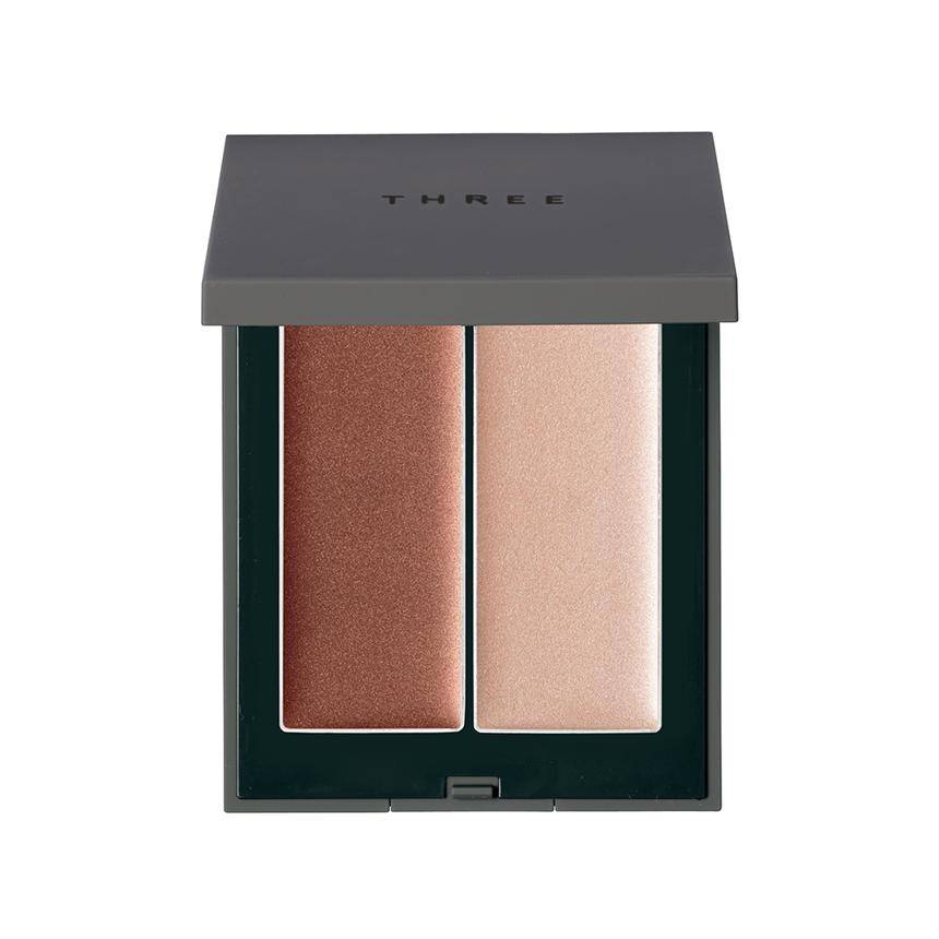 Three Shimmering Glow Duo makeup compact with dual shades for blush and bronzer, perfect for enhancing facial radiance.