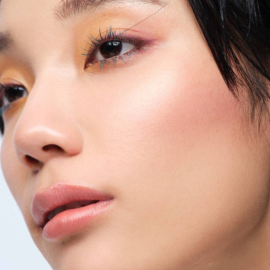 Model wearing Three Glam Tone Color Custard in a plum shade, highlighting its multi-use capabilities for a bold yet natural look.